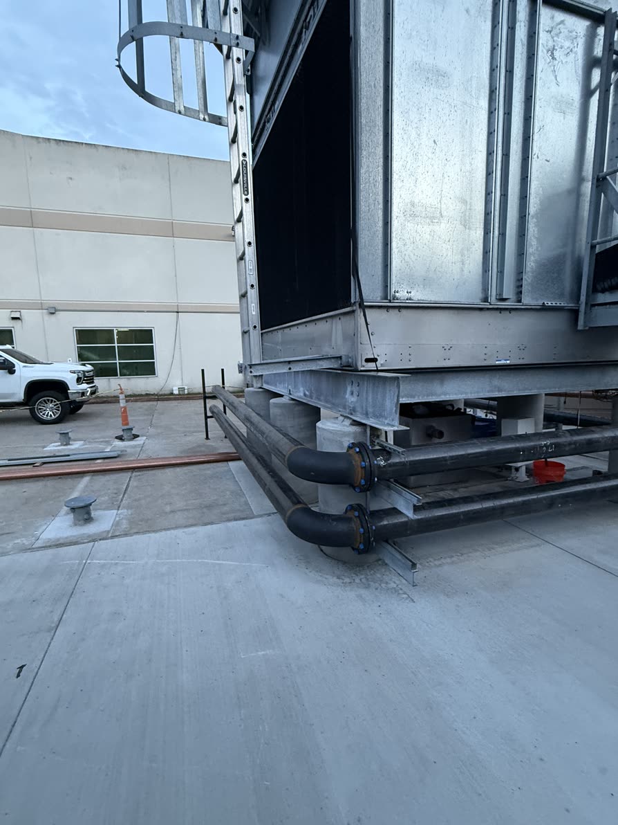 Cooling tower with large black flanged pipes